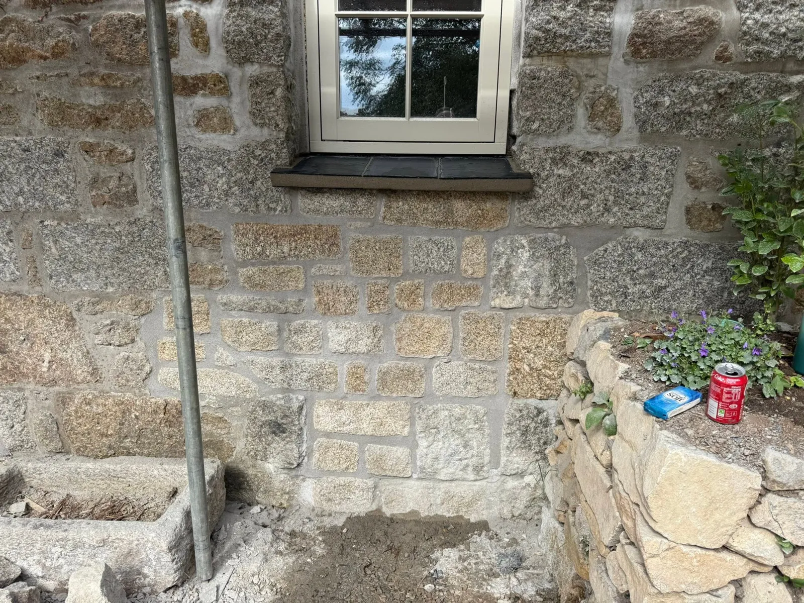 Repointing in progress on a granite wall