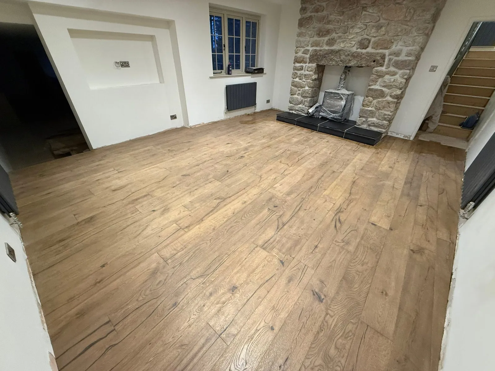 Wood floor laid up to a stone fireplace