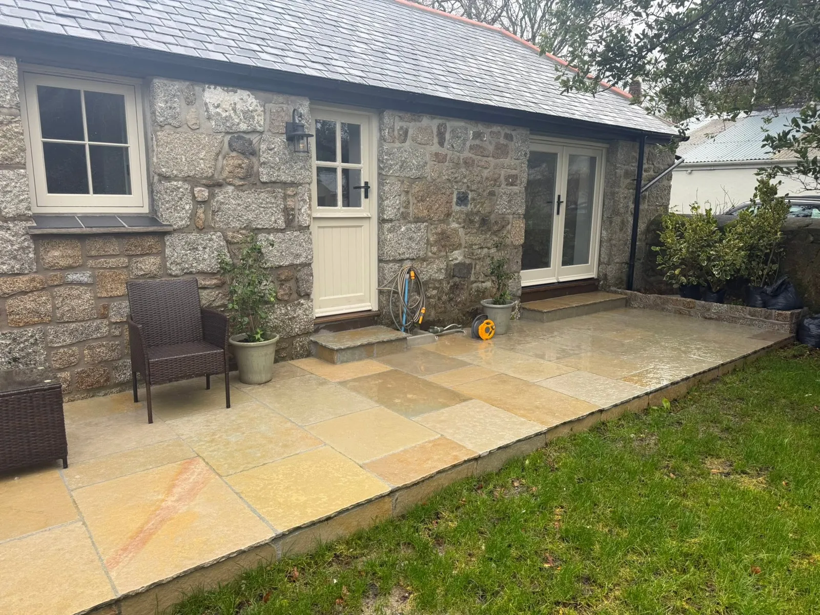 Patio laid along a granite cottage